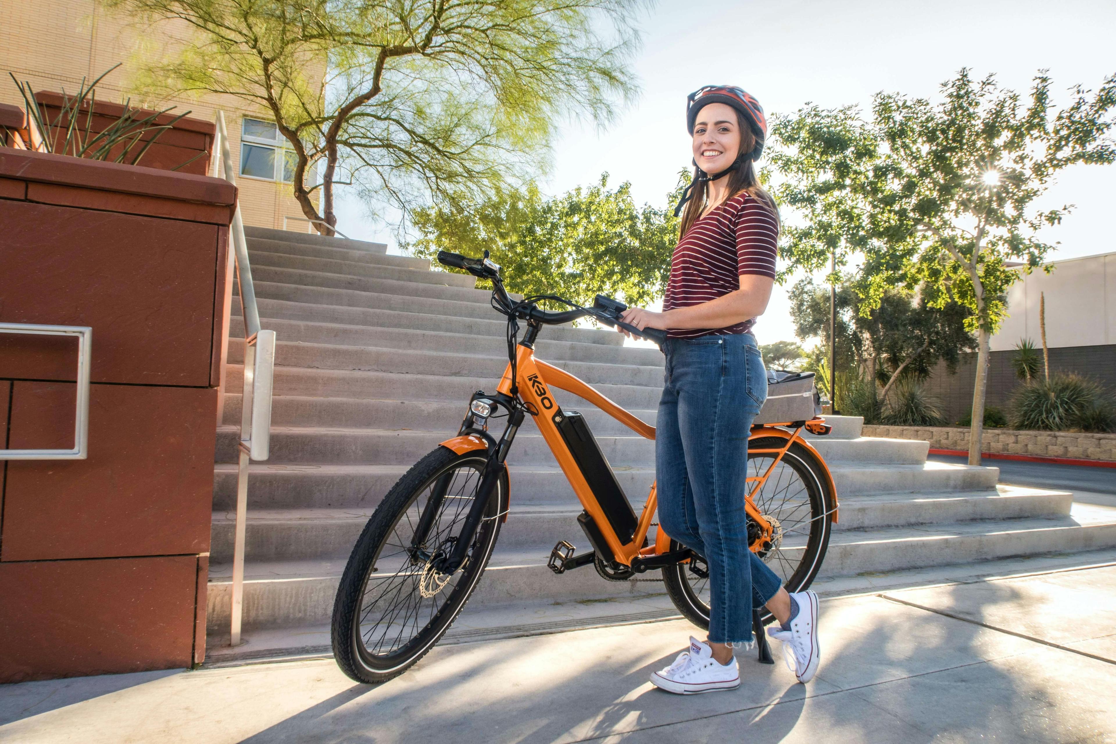 Une femme posant à côté d'un vélo