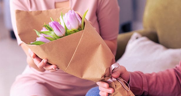 A person holding a flower bouquet